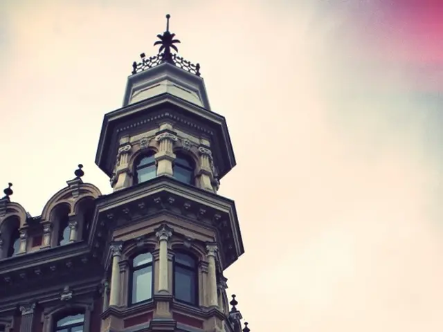 Building with glass windows. Sky is cloudy.