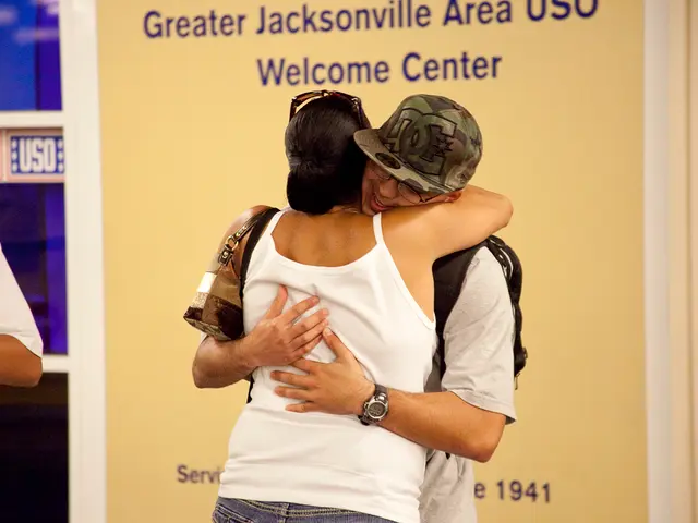 The woman in the white T-shirt is hugging the man who is wearing the white T-shirt. He is also...